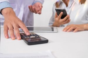 uomo e donna fanno i conti con tablet cellulare e calcolatrice
